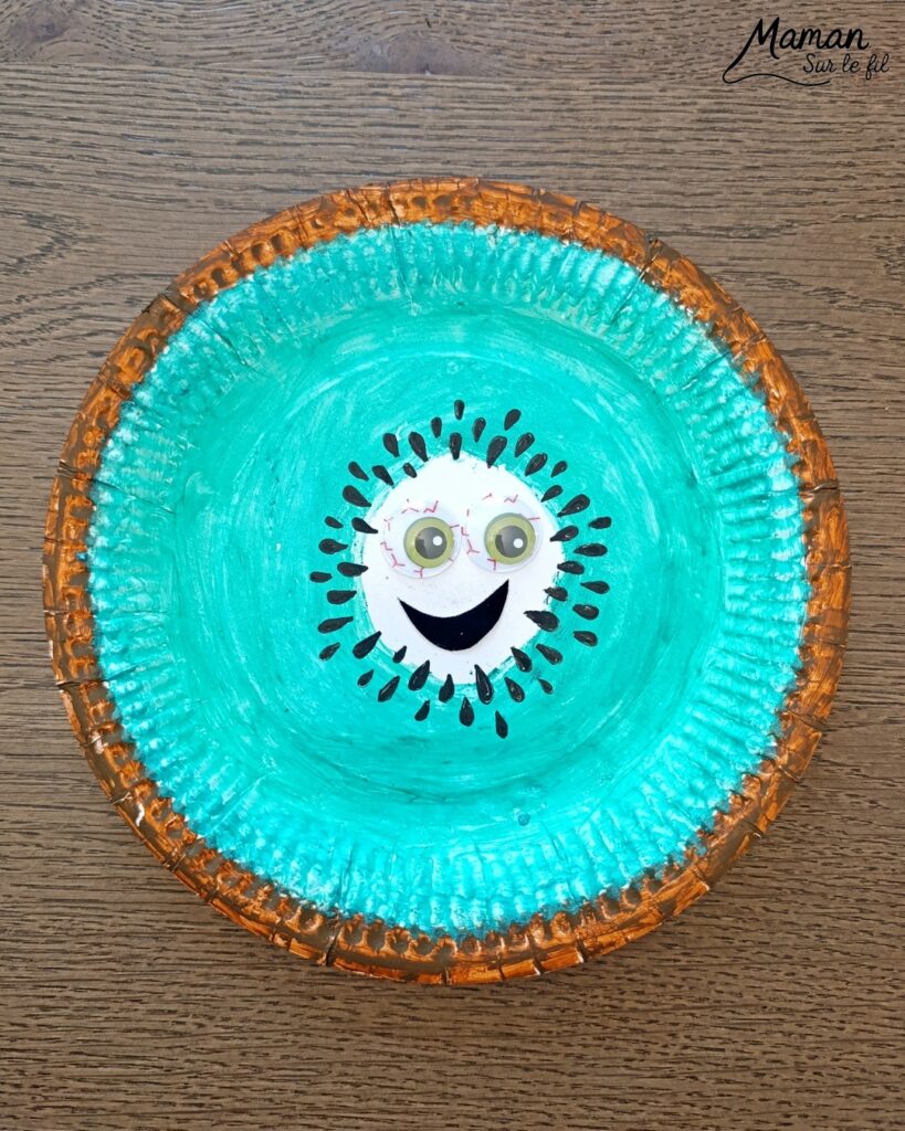 Créer un kiwi rigolo avec une assiette en carton : activité créative, peinture et manuelle enfants - Peindre le tour en marron avec de la gouache en stick, puis, le centre en vert - Dessin des pépins - Yeux mobiles flippants et bouche en papier - Décoration DIY Fait maison - Bricolage facile et rapide - Thème fruits et légumes, potager, jardinage, nature, printemps - Bricolage et décoration sympa et facile - Arts visuels maternelle et élémentaire - Cycles 1 et 2 - Créativité - tutoriel photos - mslf