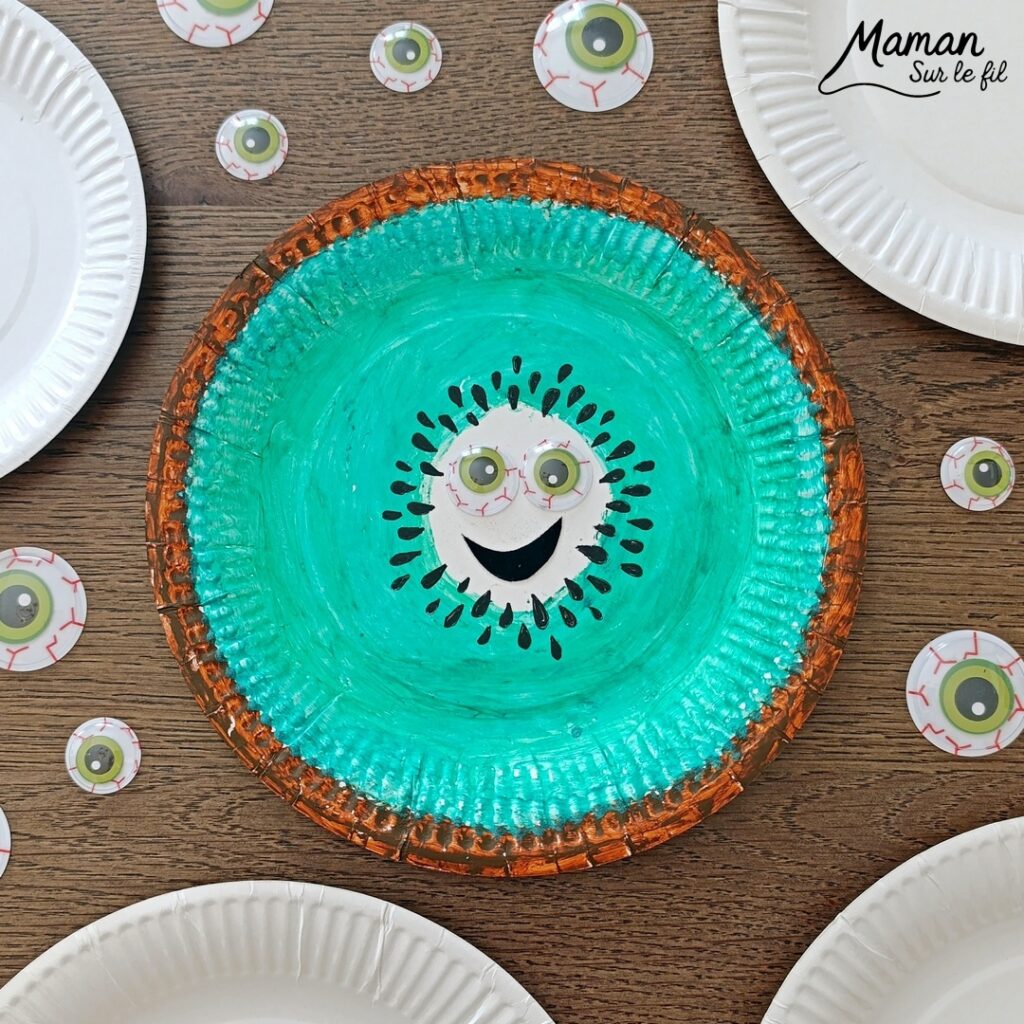 Créer un kiwi rigolo avec une assiette en carton : activité créative, peinture et manuelle enfants - Peindre le tour en marron avec de la gouache en stick, puis, le centre en vert - Dessin des pépins - Yeux mobiles flippants et bouche en papier - Décoration DIY Fait maison - Bricolage facile et rapide - Thème fruits et légumes, potager, jardinage, nature, printemps - Bricolage et décoration sympa et facile - Arts visuels maternelle et élémentaire - Cycles 1 et 2 - Créativité - tutoriel photos - mslf