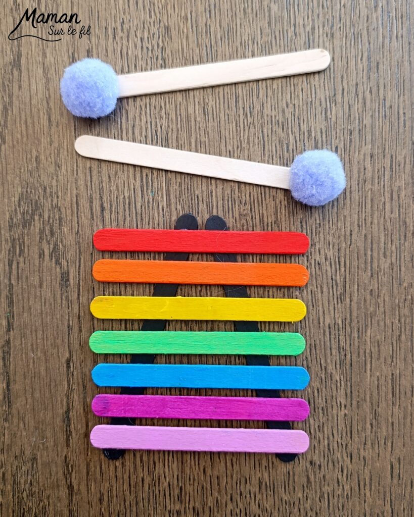 Fabriquer des instruments de musique avec des bâtonnets de glace en bois : activité créative, récup', peinture et manuelle enfants - Recyclage, surcyclage de bâtonnets de glace en bois - Gouache en stick aux couleurs de l'arc-en-ciel pour le xylophone - Pompons pour les baguettes - Noir et blanc pour le clavier de piano - Décoration DIY Fait maison - Arts visuels et Bricolage facile - Thème fête de la musique, instruments de musique, été - Bricolage et décoration sympa et facile - Arts visuels maternelle et élémentaire - Cycles 1 et 2 - Créativité - tutoriel photos - mslf
