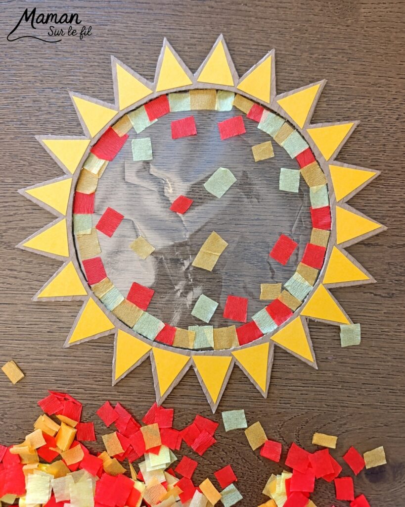 Fabriquer un soleil en récup' façon Attrape-soleil : activité créative, récup' et manuelle enfants - Recyclage, surcyclage de carton - Découpage, collage de papier pour les rayons - Papier autocollant pour couverture de livre pour le centre - Découpage et collage de petits carrés de papier crépon - Transparence - Décoration DIY Fait maison - Arts visuels et Bricolage facile - Thème été, météo - Bricolage et décoration sympa et facile - Arts visuels maternelle et élémentaire - Cycles 1 et 2 - Créativité - tutoriel photos et vidéo - mslf