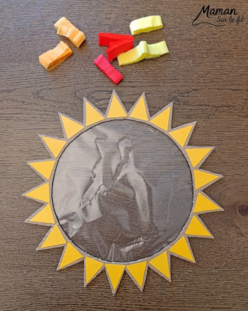 Fabriquer un soleil en récup' façon Attrape-soleil : activité créative, récup' et manuelle enfants - Recyclage, surcyclage de carton - Découpage, collage de papier pour les rayons - Papier autocollant pour couverture de livre pour le centre - Découpage et collage de petits carrés de papier crépon - Transparence - Décoration DIY Fait maison - Arts visuels et Bricolage facile - Thème été, météo - Bricolage et décoration sympa et facile - Arts visuels maternelle et élémentaire - Cycles 1 et 2 - Créativité - tutoriel photos et vidéo - mslf