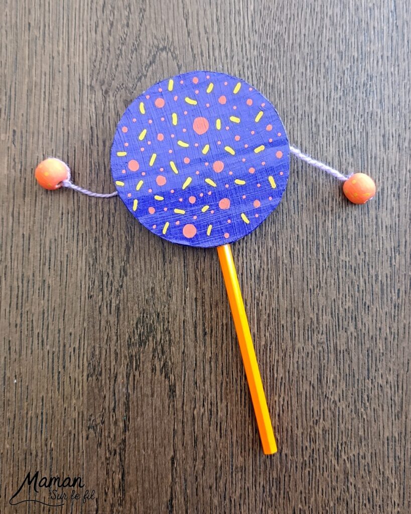 Fabriquer un petit tambourin avec du carton et des perles : activité créative, récup', peinture et manuelle enfants - Recyclage, surcyclage de carton - Cercles en carton , peinture et marqueurs Peinture pour la décoration - Crayon de couleur pour la poignée - Laine et perles en bois pour les percussions - Décoration DIY Fait maison - Arts visuels et Bricolage facile - Thème fête de la musique, instruments de musique, été - Bricolage et décoration sympa et facile - Arts visuels maternelle et élémentaire - Cycles 1 et 2 - Créativité - tutoriel photos et vidéos - mslf