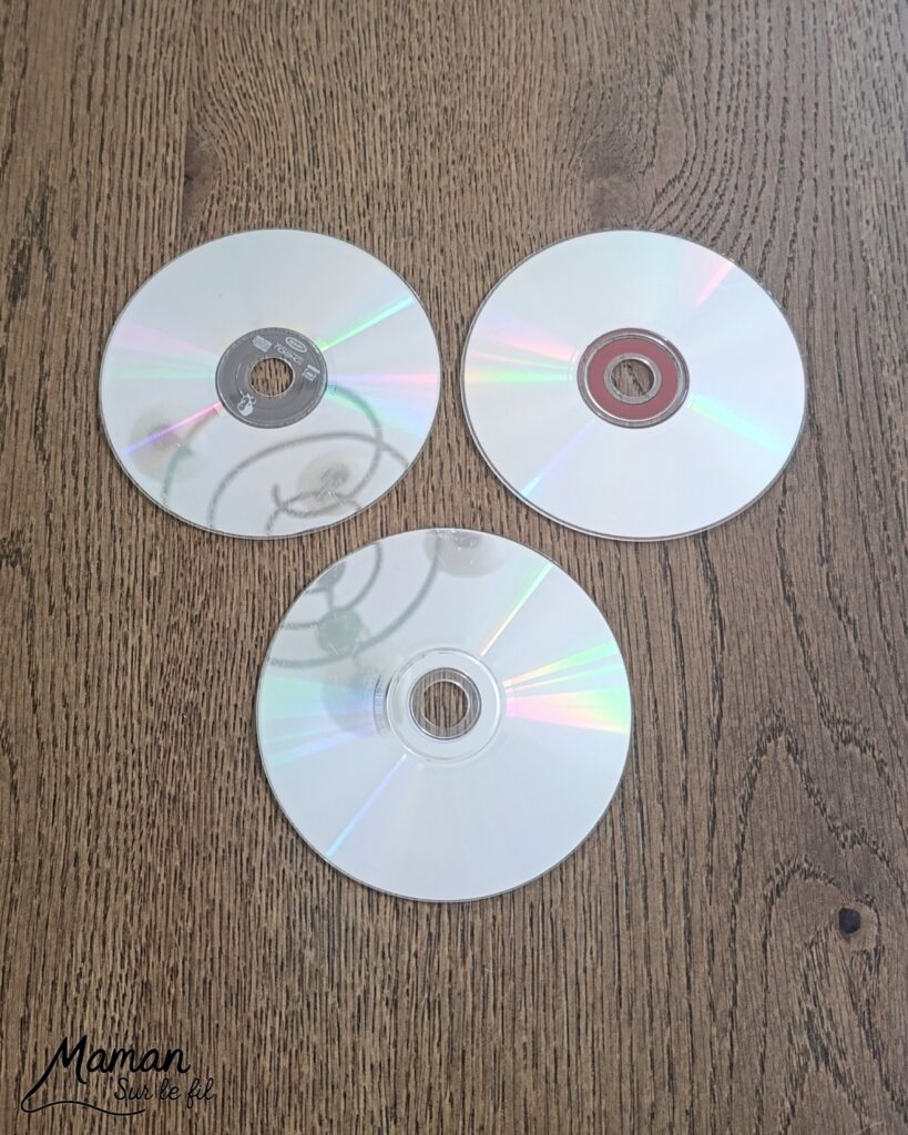 Fabriquer des boules à facettes avec des vieux CD : activité créative, récup' et manuelle enfants - Recyclage, surcyclage d'anciens compact disc (CD) abîmés - Découpage en morceaux pour le côté mosaïque - Base avec un autre CD et du papier aluminium ou noir - Collage - Bolduc argenté pour en faire une suspension - Décoration DIY Fait maison - Arts visuels et Bricolage facile - Thème fête de la musique, instruments de musique, anniversaire, jour de l'an, nouvelle année, été - Bricolage et décoration sympa et facile - Arts visuels maternelle et élémentaire - Cycles 1 et 2 - Créativité - tutoriel photos - mslf