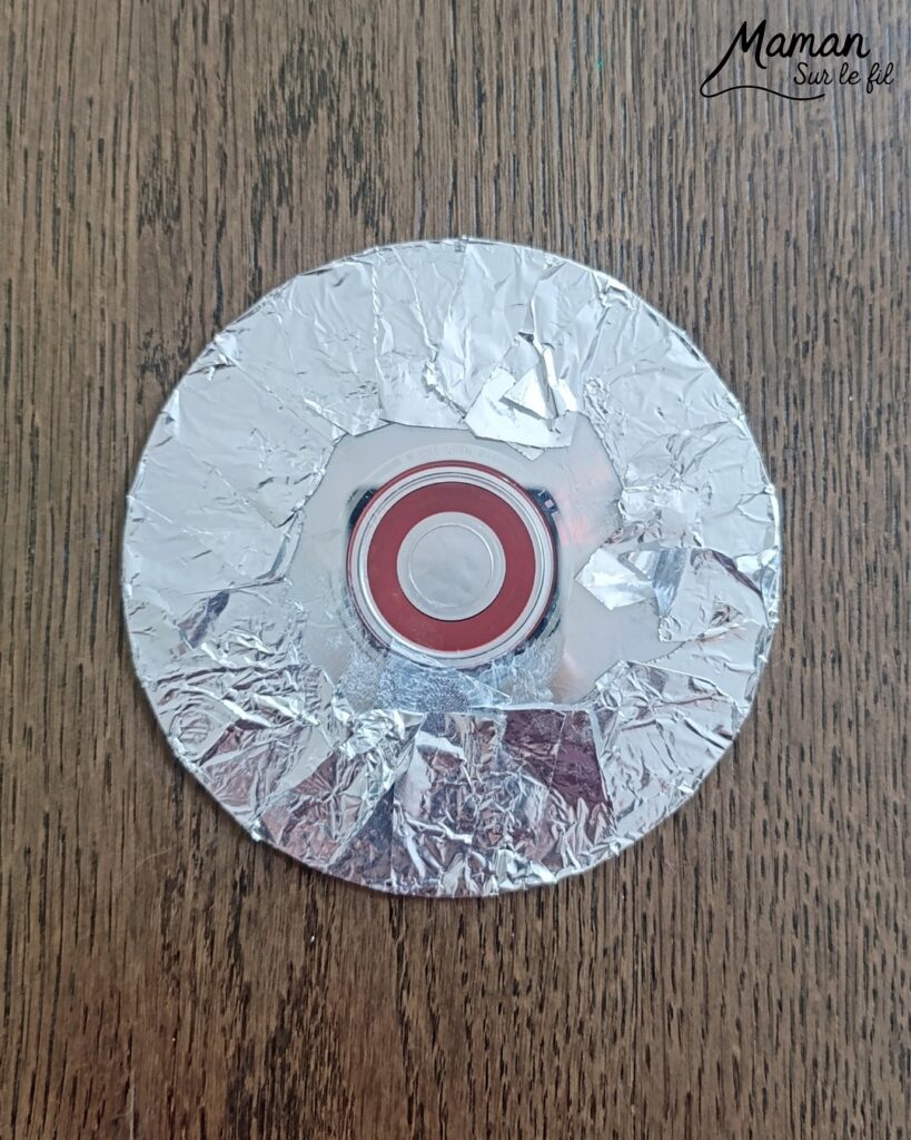 Fabriquer des boules à facettes avec des vieux CD : activité créative, récup' et manuelle enfants - Recyclage, surcyclage d'anciens compact disc (CD) abîmés - Découpage en morceaux pour le côté mosaïque - Base avec un autre CD et du papier aluminium ou noir - Collage - Bolduc argenté pour en faire une suspension - Décoration DIY Fait maison - Arts visuels et Bricolage facile - Thème fête de la musique, instruments de musique, anniversaire, jour de l'an, nouvelle année, été - Bricolage et décoration sympa et facile - Arts visuels maternelle et élémentaire - Cycles 1 et 2 - Créativité - tutoriel photos - mslf
