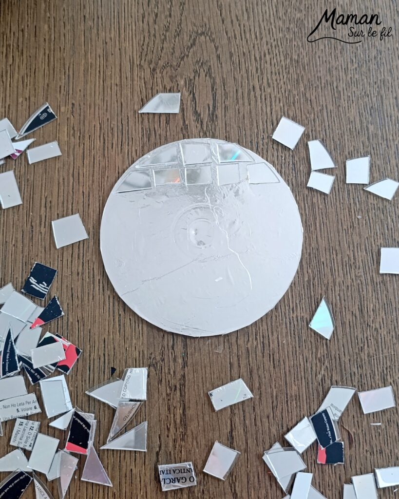 Fabriquer des boules à facettes avec des vieux CD : activité créative, récup' et manuelle enfants - Recyclage, surcyclage d'anciens compact disc (CD) abîmés - Découpage en morceaux pour le côté mosaïque - Base avec un autre CD et du papier aluminium ou noir - Collage - Bolduc argenté pour en faire une suspension - Décoration DIY Fait maison - Arts visuels et Bricolage facile - Thème fête de la musique, instruments de musique, anniversaire, jour de l'an, nouvelle année, été - Bricolage et décoration sympa et facile - Arts visuels maternelle et élémentaire - Cycles 1 et 2 - Créativité - tutoriel photos - mslf