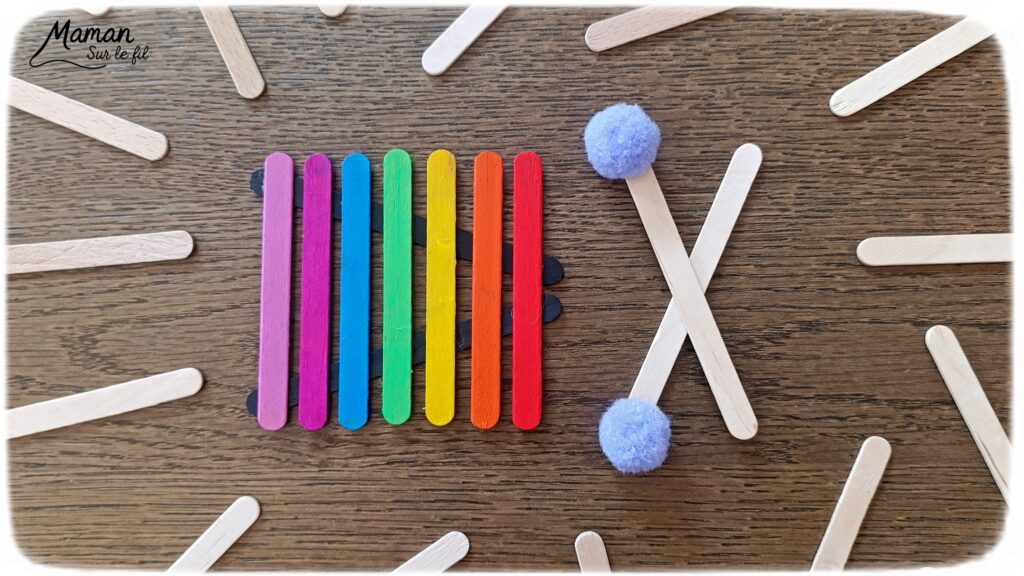 Fabriquer des instruments de musique avec des bâtonnets de glace en bois : activité créative, récup', peinture et manuelle enfants - Recyclage, surcyclage de bâtonnets de glace en bois - Gouache en stick aux couleurs de l'arc-en-ciel pour le xylophone - Pompons pour les baguettes - Noir et blanc pour le clavier de piano - Décoration DIY Fait maison - Arts visuels et Bricolage facile - Thème fête de la musique, instruments de musique, été - Bricolage et décoration sympa et facile - Arts visuels maternelle et élémentaire - Cycles 1 et 2 - Créativité - tutoriel photos - mslf