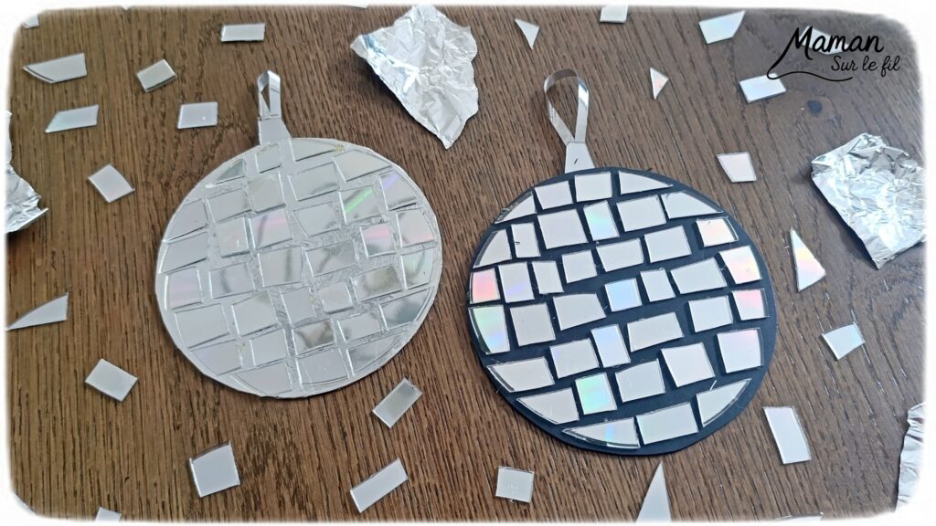 Fabriquer des boules à facettes avec des vieux CD : activité créative, récup' et manuelle enfants - Recyclage, surcyclage d'anciens compact disc (CD) abîmés - Découpage en morceaux pour le côté mosaïque - Base avec un autre CD et du papier aluminium ou noir - Collage - Bolduc argenté pour en faire une suspension - Décoration DIY Fait maison - Arts visuels et Bricolage facile - Thème fête de la musique, instruments de musique, anniversaire, jour de l'an, nouvelle année, été - Bricolage et décoration sympa et facile - Arts visuels maternelle et élémentaire - Cycles 1 et 2 - Créativité - tutoriel photos - mslf