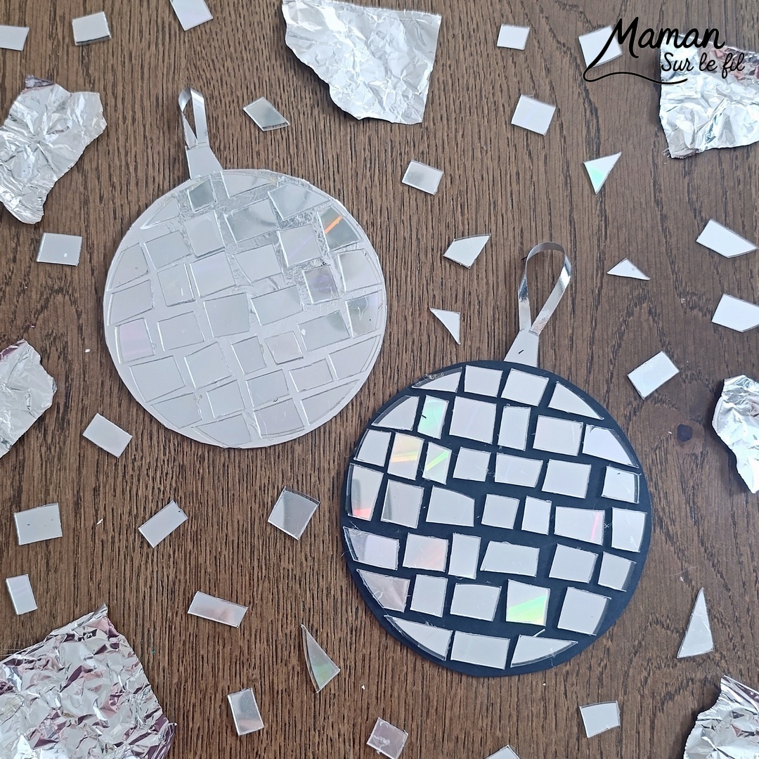 Fabriquer des boules à facettes avec des vieux CD : activité créative, récup' et manuelle enfants - Recyclage, surcyclage d'anciens compact disc (CD) abîmés - Découpage en morceaux pour le côté mosaïque - Base avec un autre CD et du papier aluminium ou noir - Collage - Bolduc argenté pour en faire une suspension - Décoration DIY Fait maison - Arts visuels et Bricolage facile - Thème fête de la musique, instruments de musique, anniversaire, jour de l'an, nouvelle année, été - Bricolage et décoration sympa et facile - Arts visuels maternelle et élémentaire - Cycles 1 et 2 - Créativité - tutoriel photos - mslf