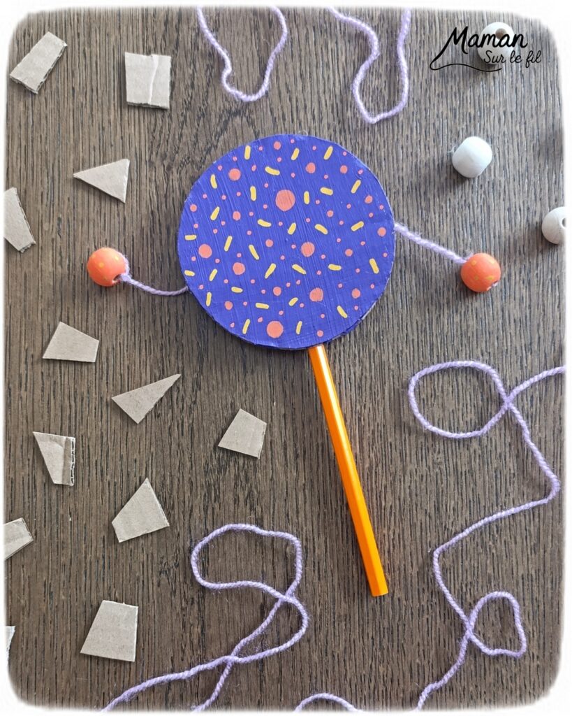 Fabriquer un petit tambourin avec du carton et des perles : activité créative, récup', peinture et manuelle enfants - Recyclage, surcyclage de carton - Cercles en carton , peinture et marqueurs Peinture pour la décoration - Crayon de couleur pour la poignée - Laine et perles en bois pour les percussions - Décoration DIY Fait maison - Arts visuels et Bricolage facile - Thème fête de la musique, instruments de musique, été - Bricolage et décoration sympa et facile - Arts visuels maternelle et élémentaire - Cycles 1 et 2 - Créativité - tutoriel photos et vidéos - mslf
