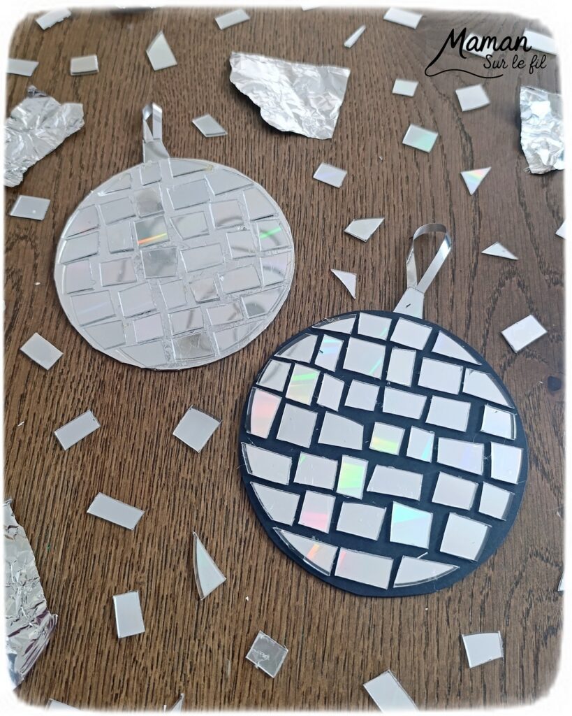 Fabriquer des boules à facettes avec des vieux CD : activité créative, récup' et manuelle enfants - Recyclage, surcyclage d'anciens compact disc (CD) abîmés - Découpage en morceaux pour le côté mosaïque - Base avec un autre CD et du papier aluminium ou noir - Collage - Bolduc argenté pour en faire une suspension - Décoration DIY Fait maison - Arts visuels et Bricolage facile - Thème fête de la musique, instruments de musique, anniversaire, jour de l'an, nouvelle année, été - Bricolage et décoration sympa et facile - Arts visuels maternelle et élémentaire - Cycles 1 et 2 - Créativité - tutoriel photos - mslf