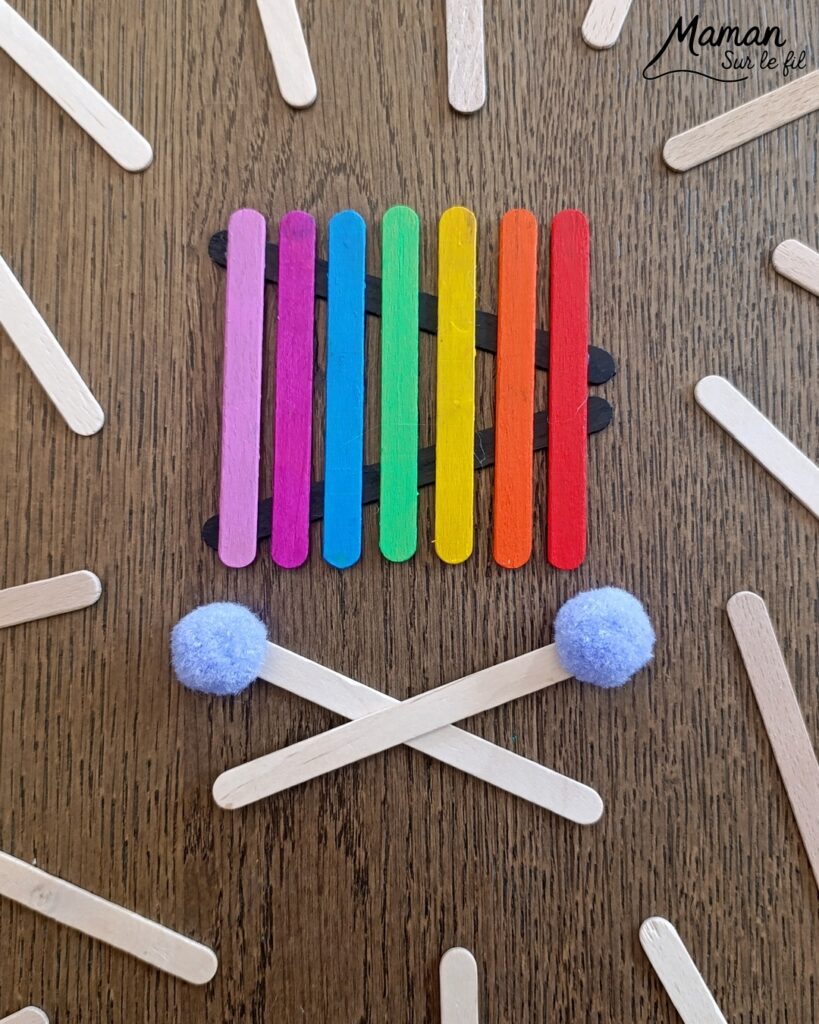 Fabriquer des instruments de musique avec des bâtonnets de glace en bois : activité créative, récup', peinture et manuelle enfants - Recyclage, surcyclage de bâtonnets de glace en bois - Gouache en stick aux couleurs de l'arc-en-ciel pour le xylophone - Pompons pour les baguettes - Noir et blanc pour le clavier de piano - Décoration DIY Fait maison - Arts visuels et Bricolage facile - Thème fête de la musique, instruments de musique, été - Bricolage et décoration sympa et facile - Arts visuels maternelle et élémentaire - Cycles 1 et 2 - Créativité - tutoriel photos - mslf