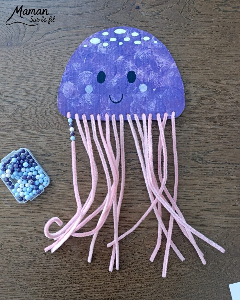 Fabriquer une méduse en carton, fils chenille et perles : activité créative, récup', peinture et manuelle enfants - Recyclage, surcyclage de carton - Peinture au tampon pour la méduse - Dessin aux marqueurs Peinture - Fils chenille pour les filaments, les tentacules - Perles à glisser sur les fils chenille pour la décoration et travailler la motricité fine - Décoration DIY Fait maison - Arts visuels et Bricolage facile - Thème animaux marins, mer, océans, plage, été - Bricolage et décoration sympa et facile - Arts visuels maternelle et élémentaire, adultes - Cycles 1 et 2 - Créativité - tutoriel photos et vidéo - mslf