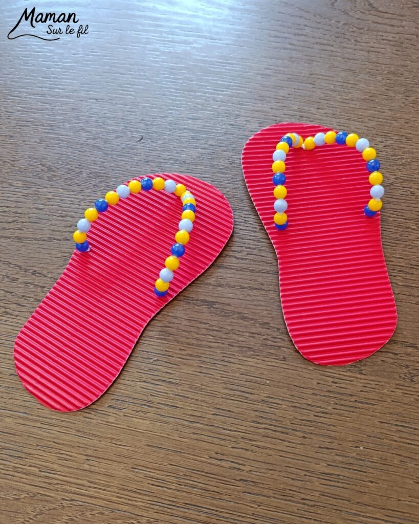 Fabriquer des tongs avec du carton ondulé, des fils chenille et des perles : activité créative et manuelle enfants - Base en carton ondulé - Lanière avec fils chenille insérés dans les trous - Décoration avec des perles enfilées sur les fils chenille - Motricité fine, précision, algorithme - Décoration DIY Fait maison - Arts visuels et Bricolage facile - Thème mer, océans, plage, été, vacances, vêtements, chaussures et accessoires - Bricolage et décoration sympa et facile - Arts visuels maternelle et élémentaire - Cycles 1 et 2 - Créativité - tutoriel photos et vidéo - mslf
