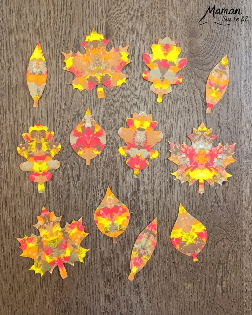 Créer une guirlande de feuilles mortes d'automne en peinture symétrique : activité créative, peinture et manuelle - Découpage des feuilles et peinture par symétrie en pliant le papier en deux - Technique de peinture pour aborder la symétrie - Couleurs chaudes et automnales - Scotchage à un fil ou à un bout de laine pour en faire une guirlande à suspendre, une suspension pour décorer - Bricolage et décoration DIY et facile - Bricolage Fait maison, décoration - Thème Forêts, Arbres, feuilles mortes, automne - Bricolage sympa et facile - Arts visuels Maternelle et cycle 2 - Maternelle et élémentaire - Créativité et lecture jeunesse - Cycle 1 ou 2 - tutoriel photos - mslf