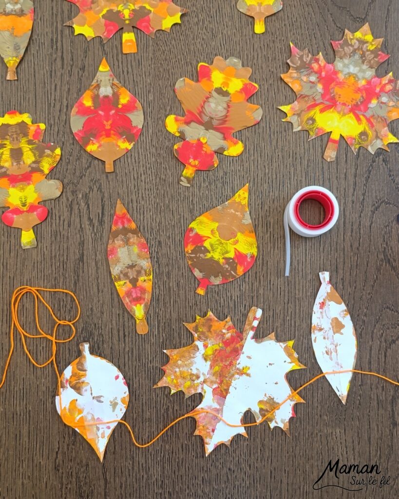 Créer une guirlande de feuilles mortes d'automne en peinture symétrique : activité créative, peinture et manuelle - Découpage des feuilles et peinture par symétrie en pliant le papier en deux - Technique de peinture pour aborder la symétrie - Couleurs chaudes et automnales - Scotchage à un fil ou à un bout de laine pour en faire une guirlande à suspendre, une suspension pour décorer - Bricolage et décoration DIY et facile - Bricolage Fait maison, décoration - Thème Forêts, Arbres, feuilles mortes, automne - Bricolage sympa et facile - Arts visuels Maternelle et cycle 2 - Maternelle et élémentaire - Créativité et lecture jeunesse - Cycle 1 ou 2 - tutoriel photos - mslf